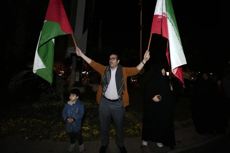 A demonstrator waves Iranian and Palestinian flags during an anti-Israeli gathering at the Felestin (Palestine) Square in Tehran, Iran, early Sunday, on April 14, 2024 — AP photo