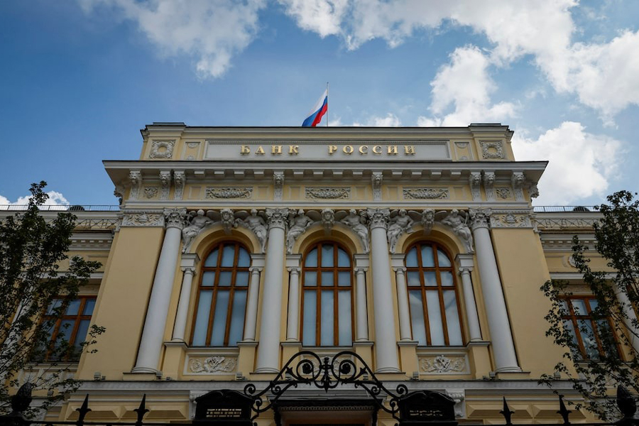 A Russian state flag flies over the Central Bank headquarters in Moscow, Russia, August 15, 2023. A sign reads: “Bank of Russia”.