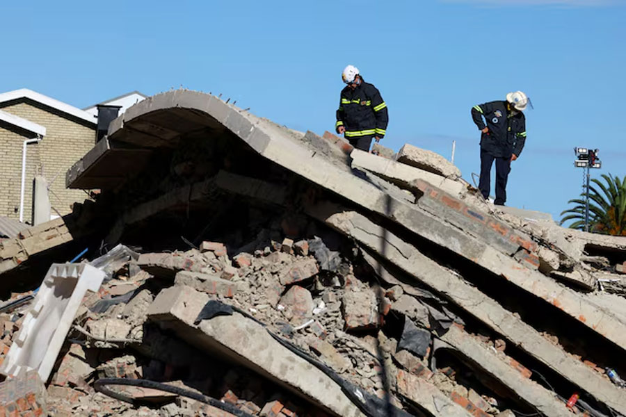 Rescuers work to rescue construction workers trapped under a building that collapsed in George, South Africa May 8, 2024.