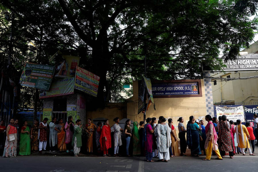 Women wait to enter a polling station to cast their votes during the fifth phase of India’s general election in Howrah district of the eastern state of West Bengal, India
