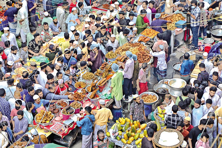 If Ramadan comes, can Chawkbazar be quiet?: With the arrival of Islamic holy month, the age-old Chawkbazar area in Old Dhaka has once again turned into an iftar hub in the capital, attracting food connoisseurs from all over the city with its offering of special delicacies. The photo of the traditional iftar market was shot on Friday afternoon. — FE photo by Shafiqul Alam