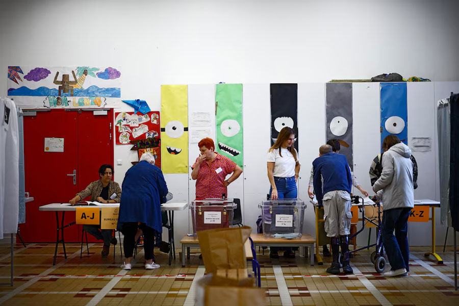 People vote in the second round of the early French parliamentary elections, at a polling station in Paris, France, July 7, 2024.