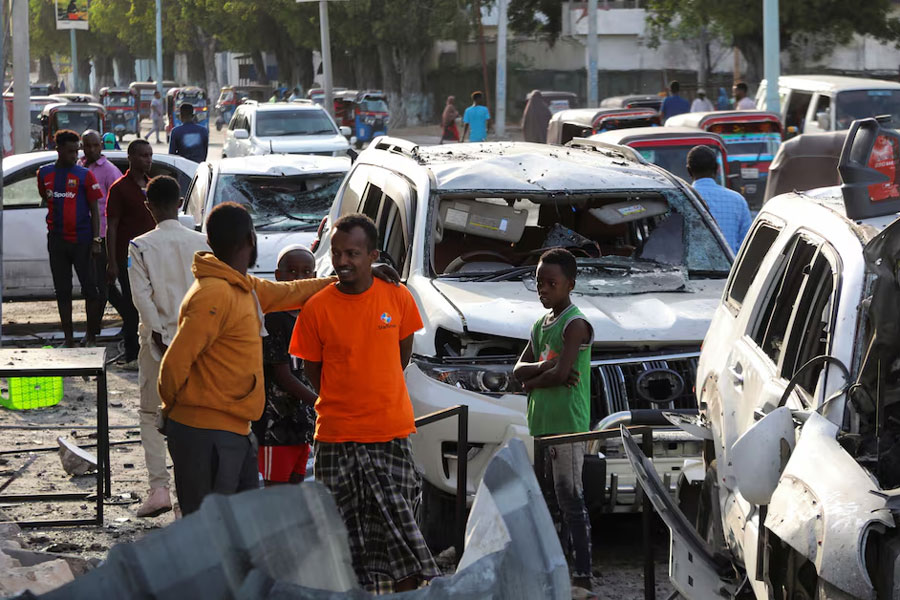People gather near the wreckages of vehicles destroyed at the scene of an explosion outside a restaurant where patrons were watching the final of the Euro 2024 football tournament on TV, in Bondhere district of Mogadishu, Somalia July 15, 2024.