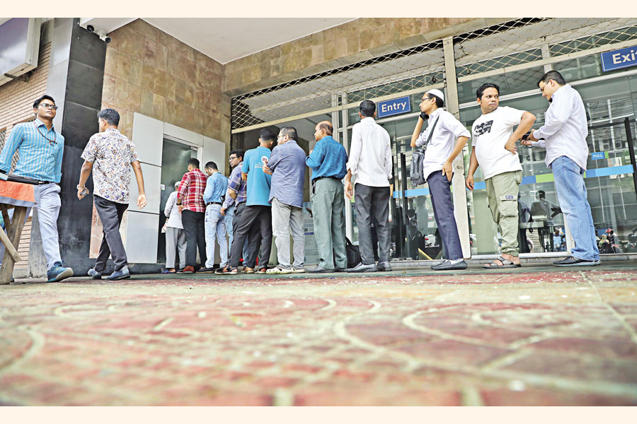A long queue forms at an ATM booth at Motijheel of Dhaka, as life starts returning to normal after a five-day holiday prompted by unrest and curfew. — FE Photo by Shafiqul Alam