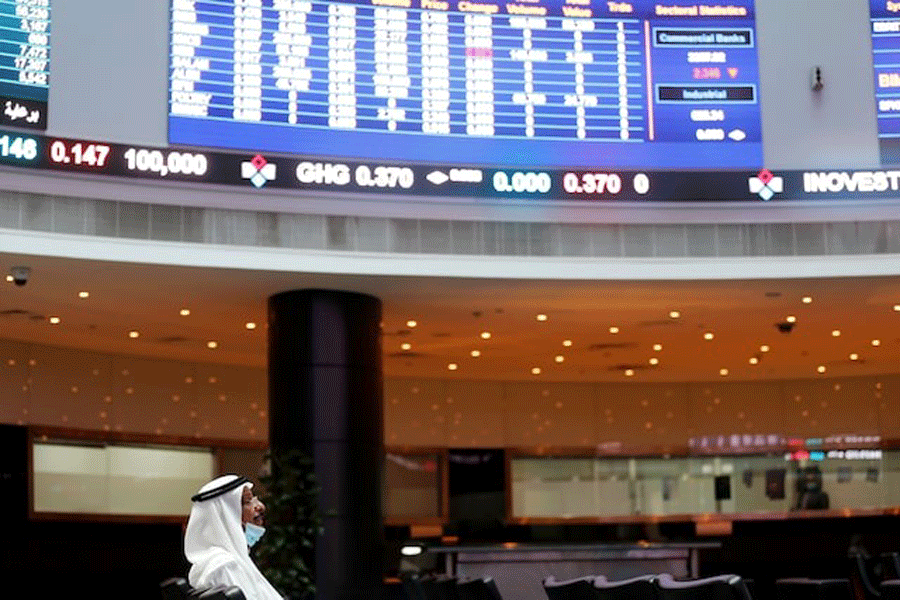 A trader looks on near electronic boards showing stock market data at Bahrain Bourse after Joe Biden won the US presidency, in Manama, Bahrain, November 8, 2020.