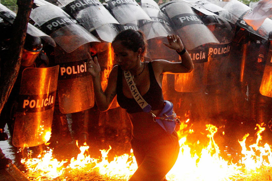 A demonstrator reacts when Molotov cocktails hit the ground in front of security forces during protests against election results after Venezuela’s President Nicolas Maduro and his opposition rival Edmundo Gonzalez claimed victory in Sunday’s presidential election, in Puerto La Cruz, Venezuela July 29, 2024.