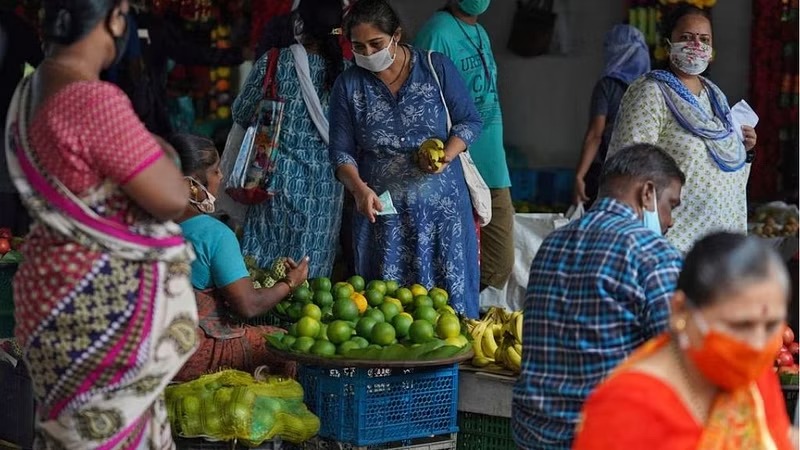 A woman wearing a protective face mask buys fruit in a market, amidst the spread of the coronavirus disease (COVID-19) in Mumbai, India, Aug 20, 2020.