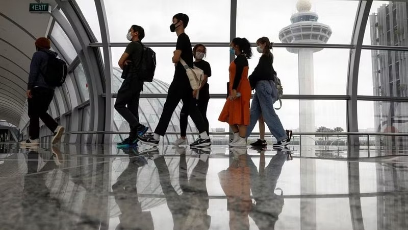 People pass the control tower of Singapore's Changi Airport, Singapore, Jan 18, 2021.