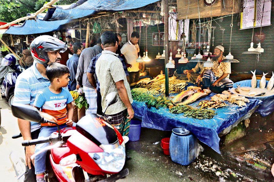 People are making a careful choice to buy fish at a shop at AGB Colony kitchen market in Dhaka's Motijheel area on Saturday. —FE photo