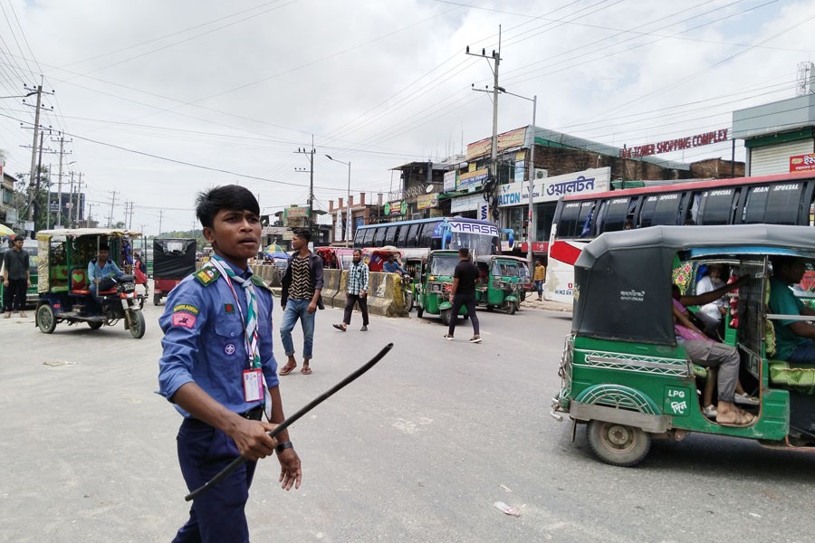 Photo shows a student controlling traffic on a road in Ramu upazila headquarters of Cox's Bazar on Wednesday, August 7 — FE photo