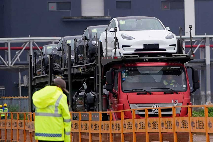 A truck transports new Tesla cars at its factory in Shanghai, China, May 13, 2021.