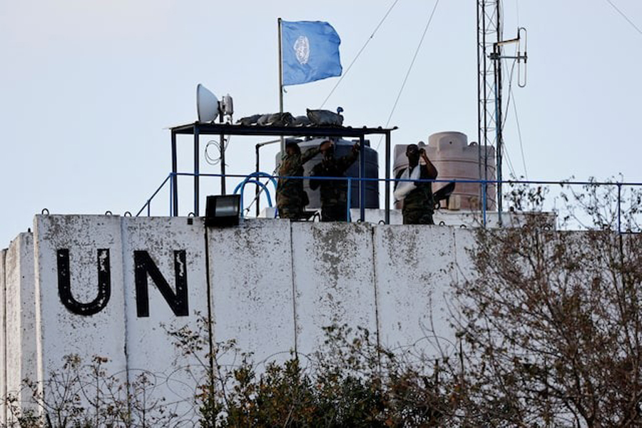 Members of the United Nations peacekeepers (UNIFIL) look at the Lebanese-Israeli border, as they stand on the roof of a watch tower in the town of Marwahin, in southern Lebanon, October 12, 2023.