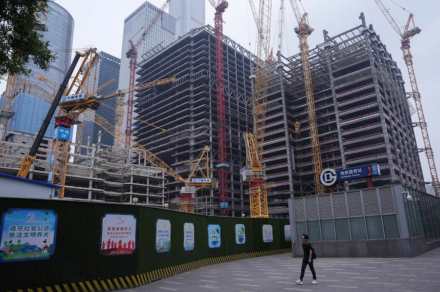 Person walks past a construction site in Beijing’s Central Business District (CBD) Beijing, July 14, 2024.