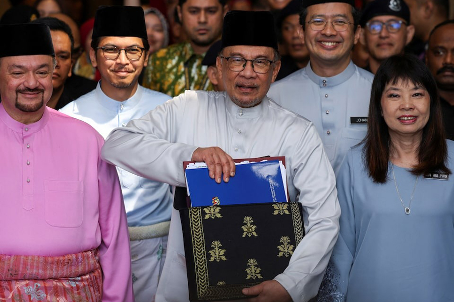 Malaysia's Prime Minister and Finance Minister Anwar Ibrahim holds the 2025 Malaysia budget document at the Finance Ministry building, as he departs to the Parliament, in Putrajaya, Malaysia, October 18, 2024.