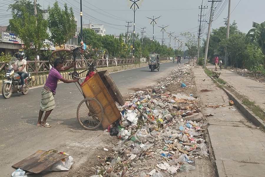 Garbage being dumped haphazardly on the Kadirganj-New Market Road of the Rajshahi city, creating an obnoxious environment