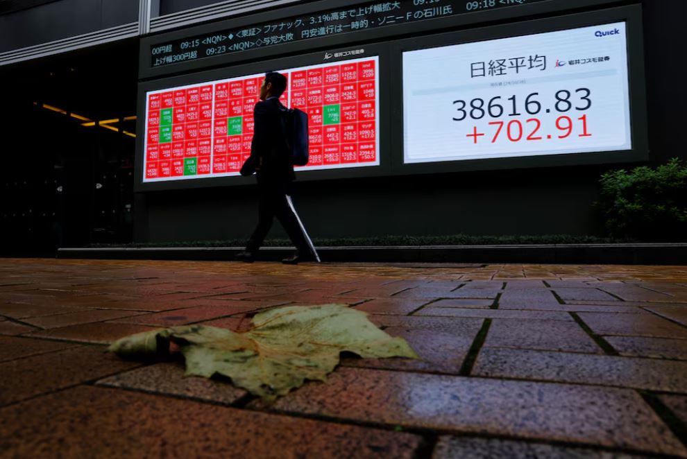 A passerby walks past an electronic screen displaying the Nikkei stock average outside a brokerage in Tokyo, Japan October 28, 2024. REUTERS/Kim Kyung-Hoon