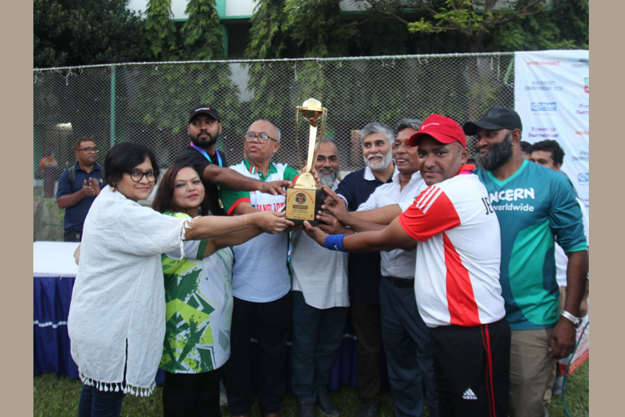 Captain of Save the Children holding the champion trophy with the guests at the cricket tournament held at Lalmatia Housing Society school ground in Dhaka with the participation of the staff of the leading non-governmental development organization working in Bangladesh, Photo – Asad Rassel
