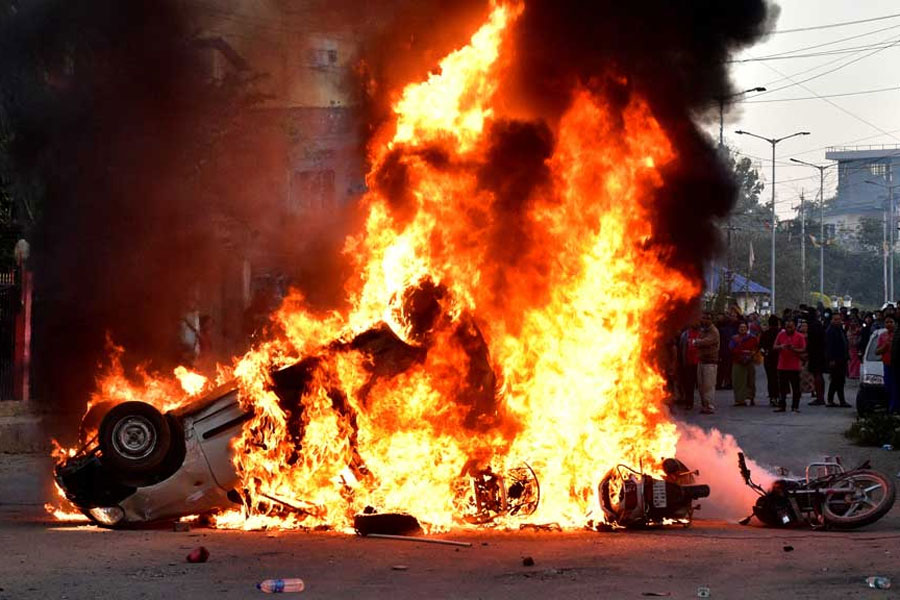 Vehicles burn as demonstrators stand during a protest against the recent killings, in Imphal West, in the northeastern state of Manipur, India, Nov 16, 2024.
