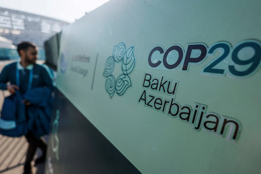 A man walks past a logo of the COP29 United Nations climate change conference, in Baku, Azerbaijan November 22, 2024.