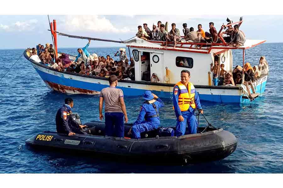Rohingya refugees rescued by fishermen are seen on a boat behind a patrol boat near the coast of Seunuddon beach in North Aceh, Indonesia, Jun 24, 2020.
