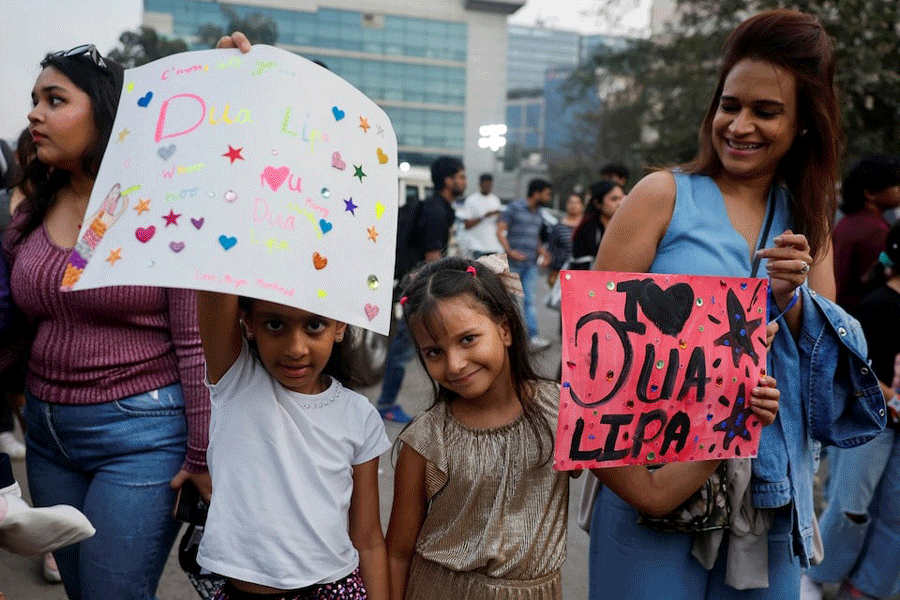 Girls hold posters outside the venue of the Dua Lipa concert in Mumbai, India November 30, 2024.