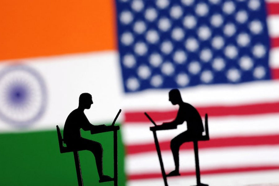 The Indian flag, the US flag and people miniatures with laptops are seen in this illustration taken March 10, 2024.