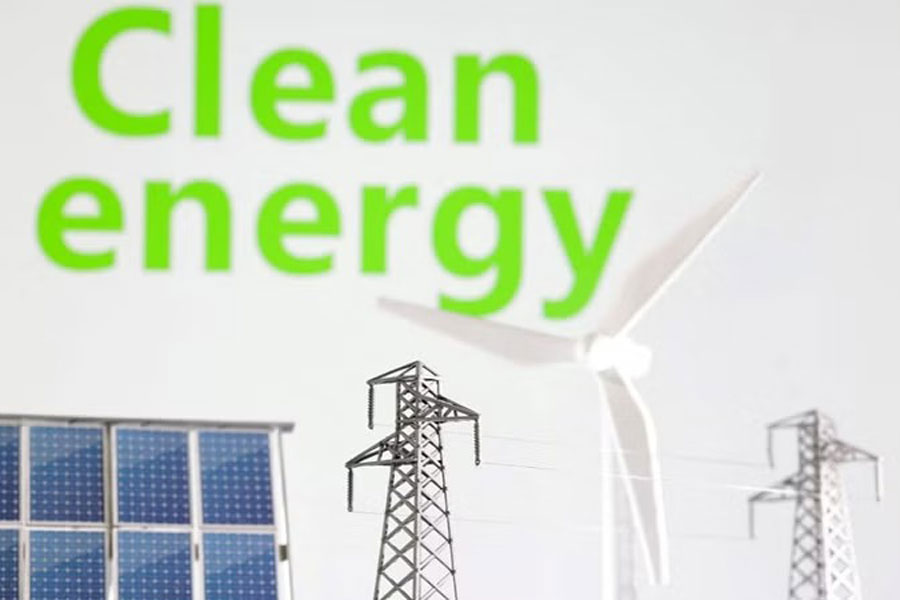 Miniatures of windmill, solar panel and electric pole are seen in front of words Clean energy in this illustration taken on Jan 17, 2023.