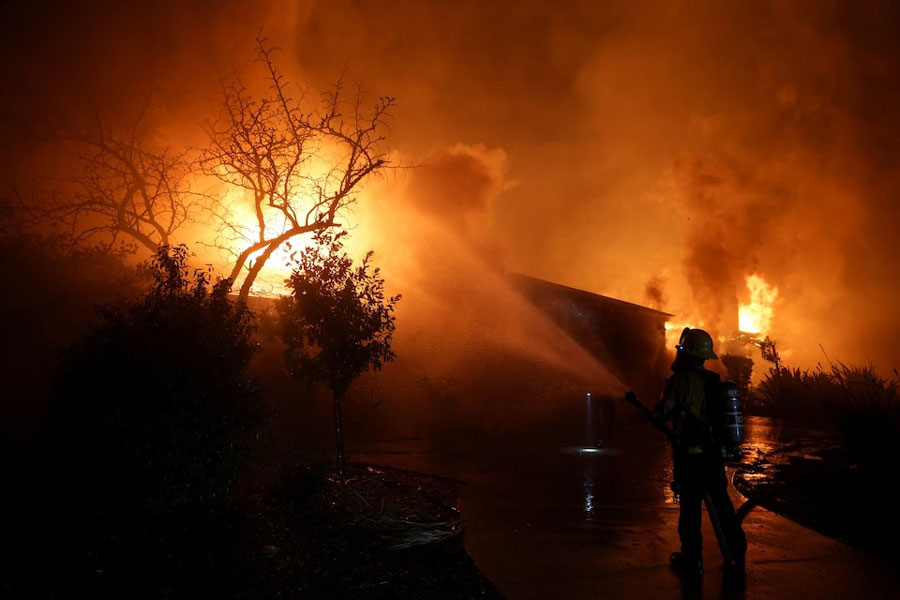 A firefighter works to extinguish flames as the Eaton Fire burns in Pasadena, California, US, January 8, 2025.
