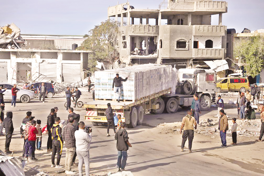 People gather around a truck loaded with humanitarian aid in the southern Gaza Strip City of Rafah, on January 19, 2025