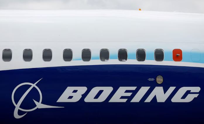 The Boeing logo is seen on the side of a Boeing 737 MAX at the Farnborough International Airshow, in Farnborough, Britain, July 20, 2022. REUTERS/Peter Cziborra/File Photo
