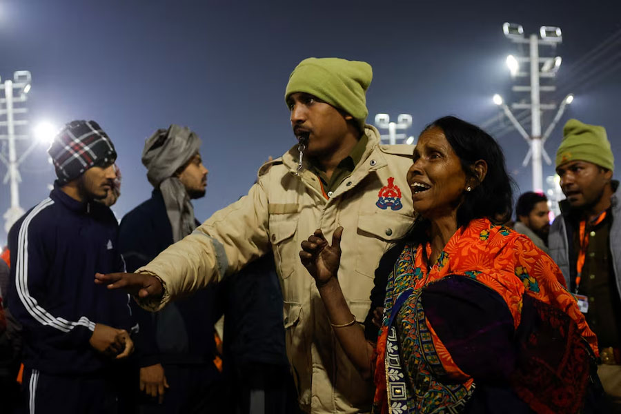 A policeman escorts a devotee after a stampede before the second “Shahi Snan” (royal bath) at the “Maha Kumbh Mela” or the Great Pitcher Festival, in Prayagraj, India, January 29, 2025.