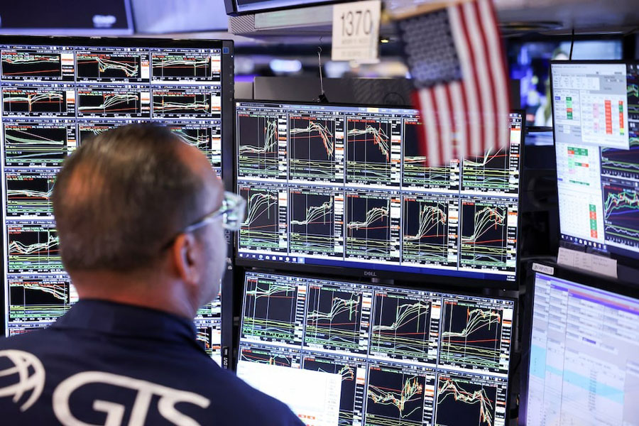 A trader works at the New York Stock Exchange (NYSE) next to a US flag, after Republican Donald Trump won the US presidential election, in New York City, US, November 6, 2024.