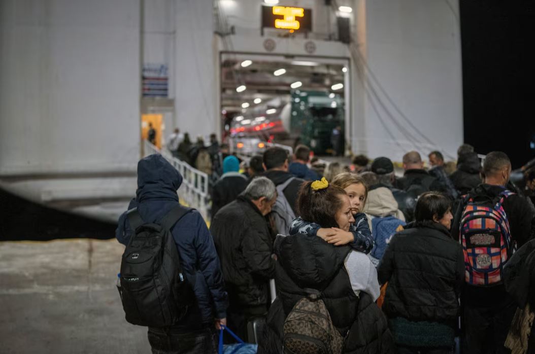 A woman carries her daughter as people board a ferry to Piraeus, following an increase in seismic activity on the island of Santorini, Greece, February 4, 2025. REUTERS/Alkis Konstantinidis