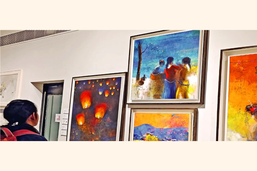 A young girl stands before the artwork presented during The Story of Art event at Aloki Gallery in Dhaka recently