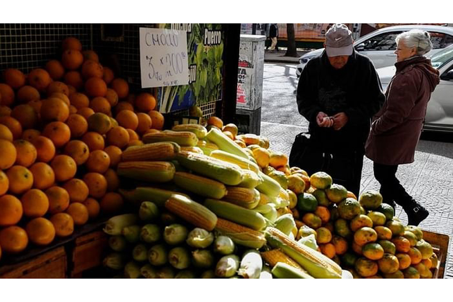 A costumer counts money before buying tangerines in a green grocery store, as Argentines struggle amid rising inflation, in Buenos Aires, Argentina, May 11, 2023.