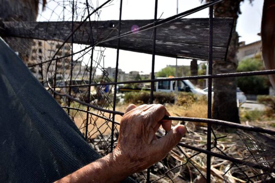 A man holds a fence in an area fenced off by the Turkish military since 1974 in the abandoned coastal area of Varosha, a suburb of the town of Famagusta in Turkish-controlled northern Cyprus, October 8, 2020.