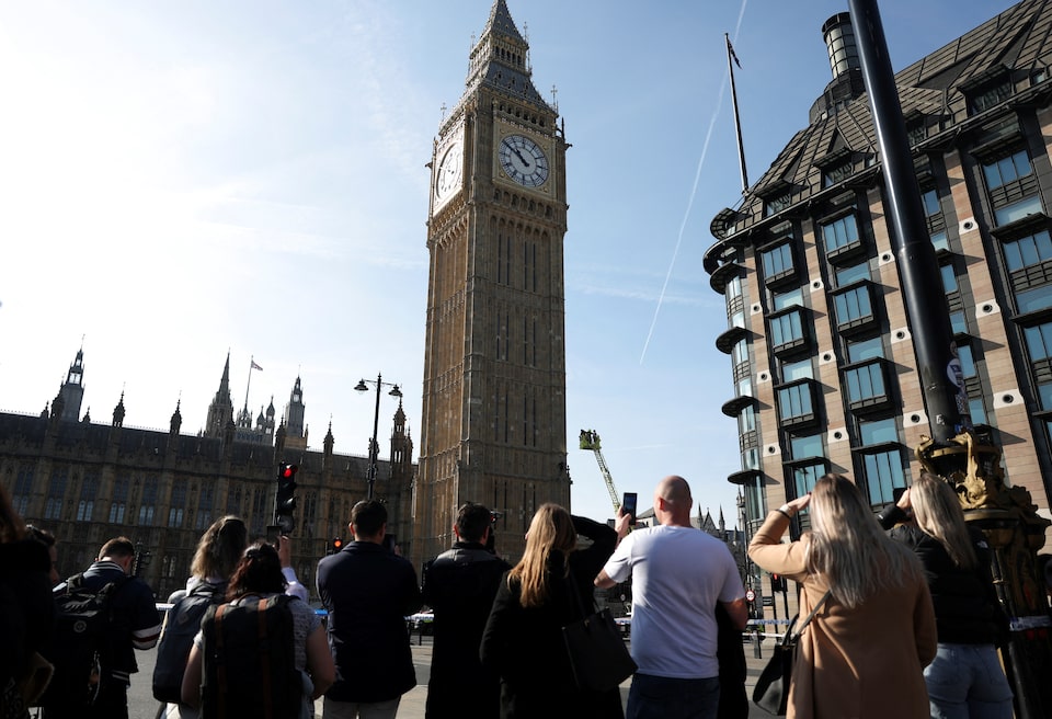 Passersby look at a man with a Palestinian flag standing on the Elizabeth Tower, commonly known as Big Ben, next to Houses of Parliament, in London, Britain March 8, 2025. REUTERS/Hannah McKay