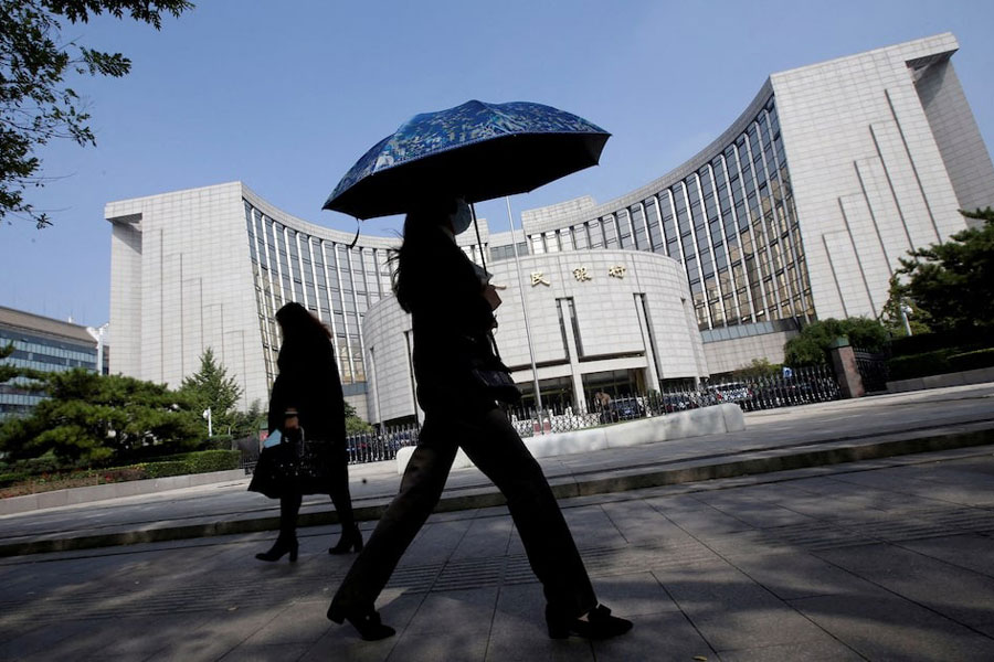 People walk past the headquarters of the People's Bank of China (PBOC), the central bank, in Beijing, China September 28, 2018.