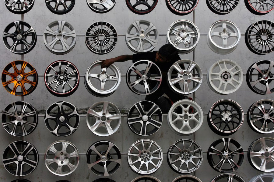 A worker displays alloy wheels for sale in India's Hyderabad.