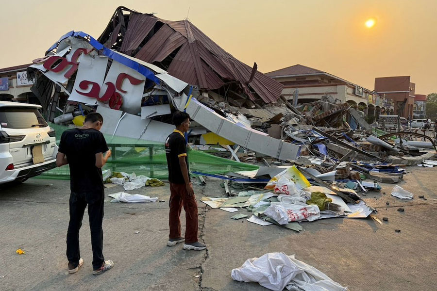 People stand near a commercial facility which collapsed due to an earthquake, in Naypyitaw, Myanmar March 29, 2025, in this photo released by Kyodo.