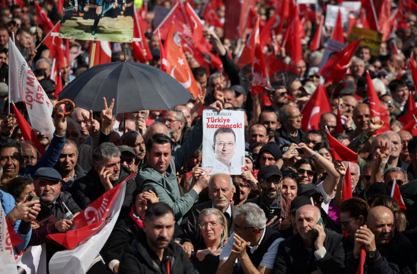 People hold up a poster reading, "Turkey will win", at a rally, to protest against the arrest of Istanbul Mayor Ekrem Imamoglu as part of a corruption investigation, in Istanbul, Turkey, March 29, 2025. REUTERS/Louisa Gouliamaki