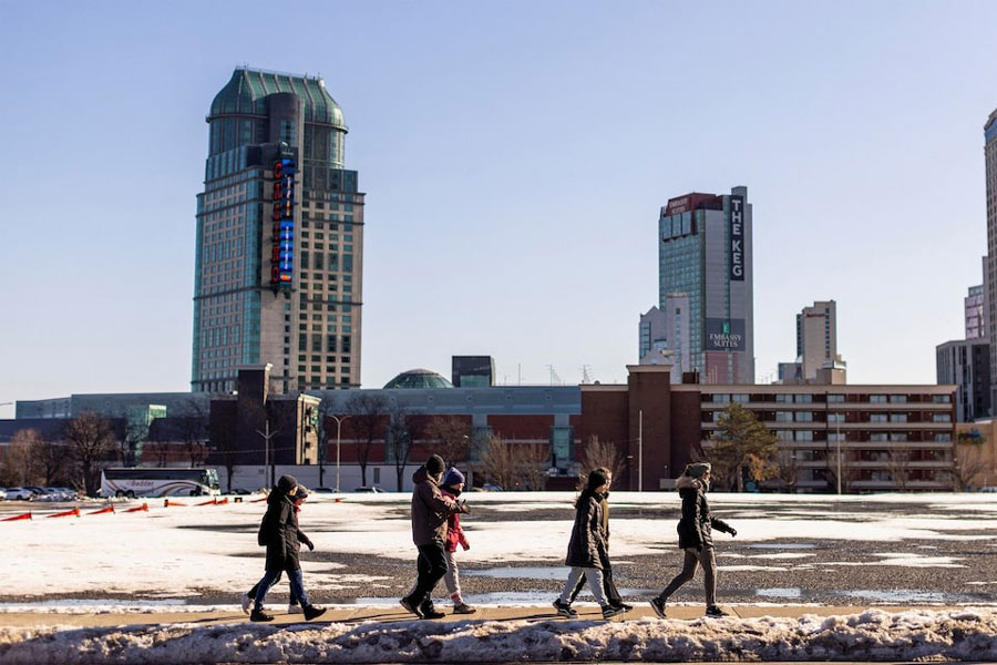 A group of people walk along a road, in Niagara Falls, Ontario, Canada March 7, 2023.