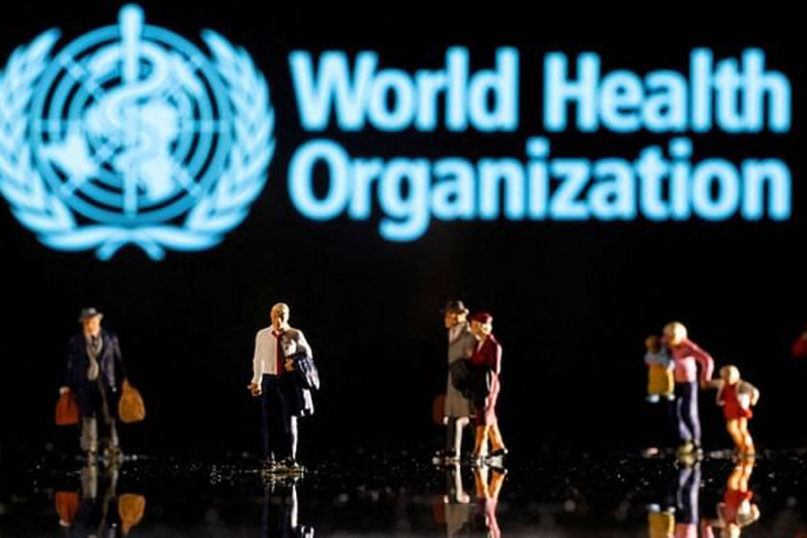 Small figurines are seen in front of displayed World Health Organization logo in this illustration taken Feb 11, 2022.