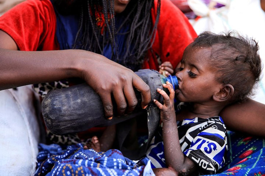 A severely malnourished child drinks from a bottle, at a camp for internally displaced people in Afdera town, Afar region, Ethiopia, February 23, 2022.