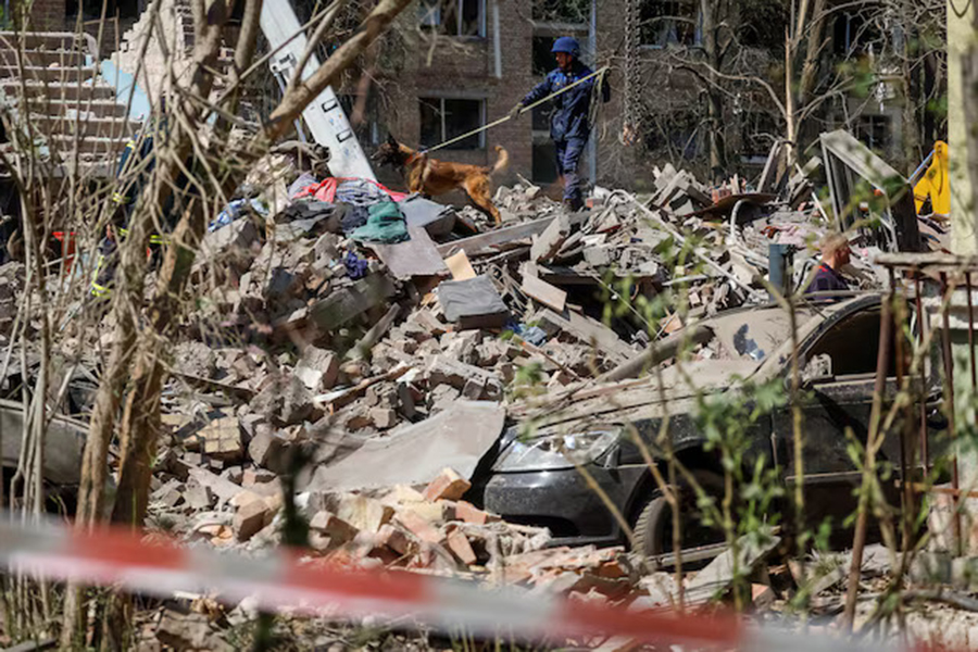 A rescuer with a service dog looks for residents, who could still be under rubber of a destroyed residential building, which was hit during a Russian missile strike, amid Russia's attack on Ukraine, in Kyiv, Ukraine on April 24, 2025 — Reuters photo