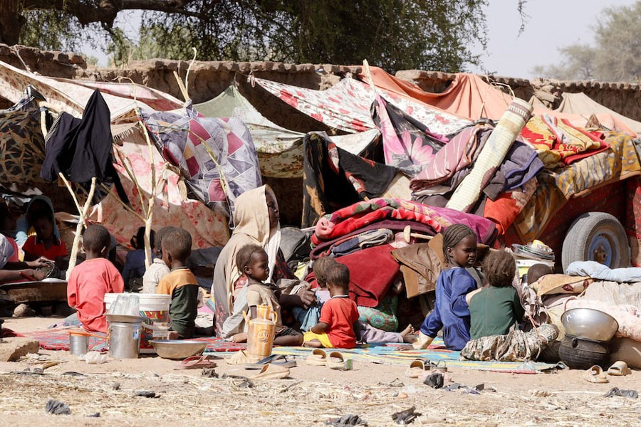 A displaced Sudanese woman looks on next children, following Rapid Support Forces (RSF) attacks on Zamzam displacement camp, as she shelters in the town of Tawila, North Darfur, Sudan, April 15, 2025.