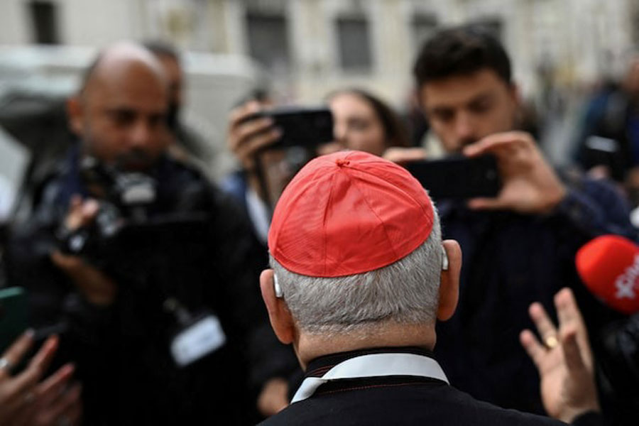 A cardinal speaks to the media as he arrives for a general congregation meeting ahead of the conclave to elect the next pope, as seen from Rome, Italy, May 5, 2025.
