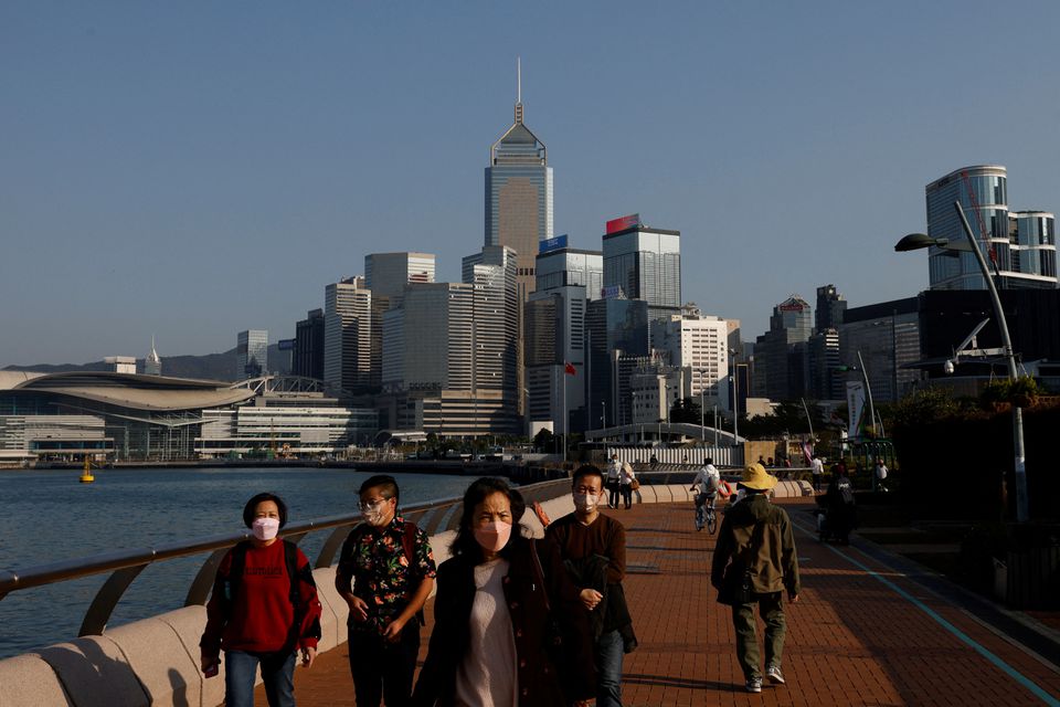 People wearing face masks walk on the street during the coronavirus disease (COVID-19) pandemic in Hong Kong, China, December 28, 2022. REUTERS/Tyrone Siu