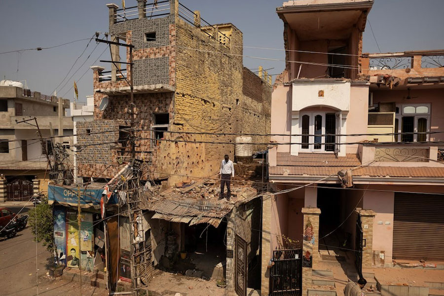 A man stands amidst the debris on the roof of a damaged house, following Pakistan's military operation against India, in Rehari, Jammu, May 10, 2025.