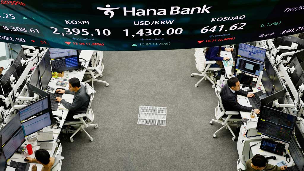 FILE PHOTO: Currency dealers work as an electronic board shows the Korean Composite Stock Price Index (KOSPI) and the exchange rate between the US dollar and South Korean won at a dealing room of a bank, in Seoul, South Korea, Dec 9, 2024. REUTERS/Kim Kyung-Hoon/File Photo